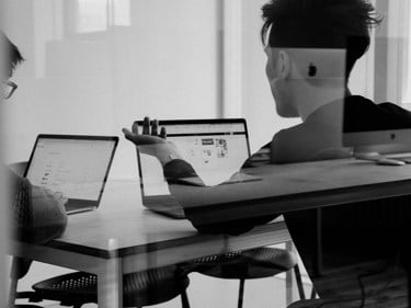 Två personer diskuterar i ett konferensrum